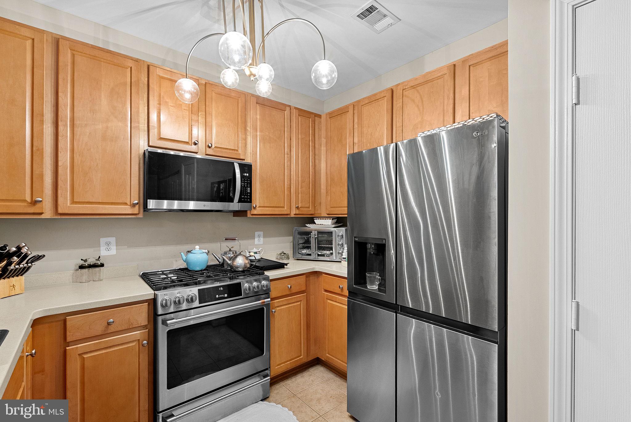 12001 Market Street, Unit 106 Reston, VA 20190 - Photo 16 of 45 a kitchen with stainless steel appliances granite countertop a refrigerator stove microwave and sink