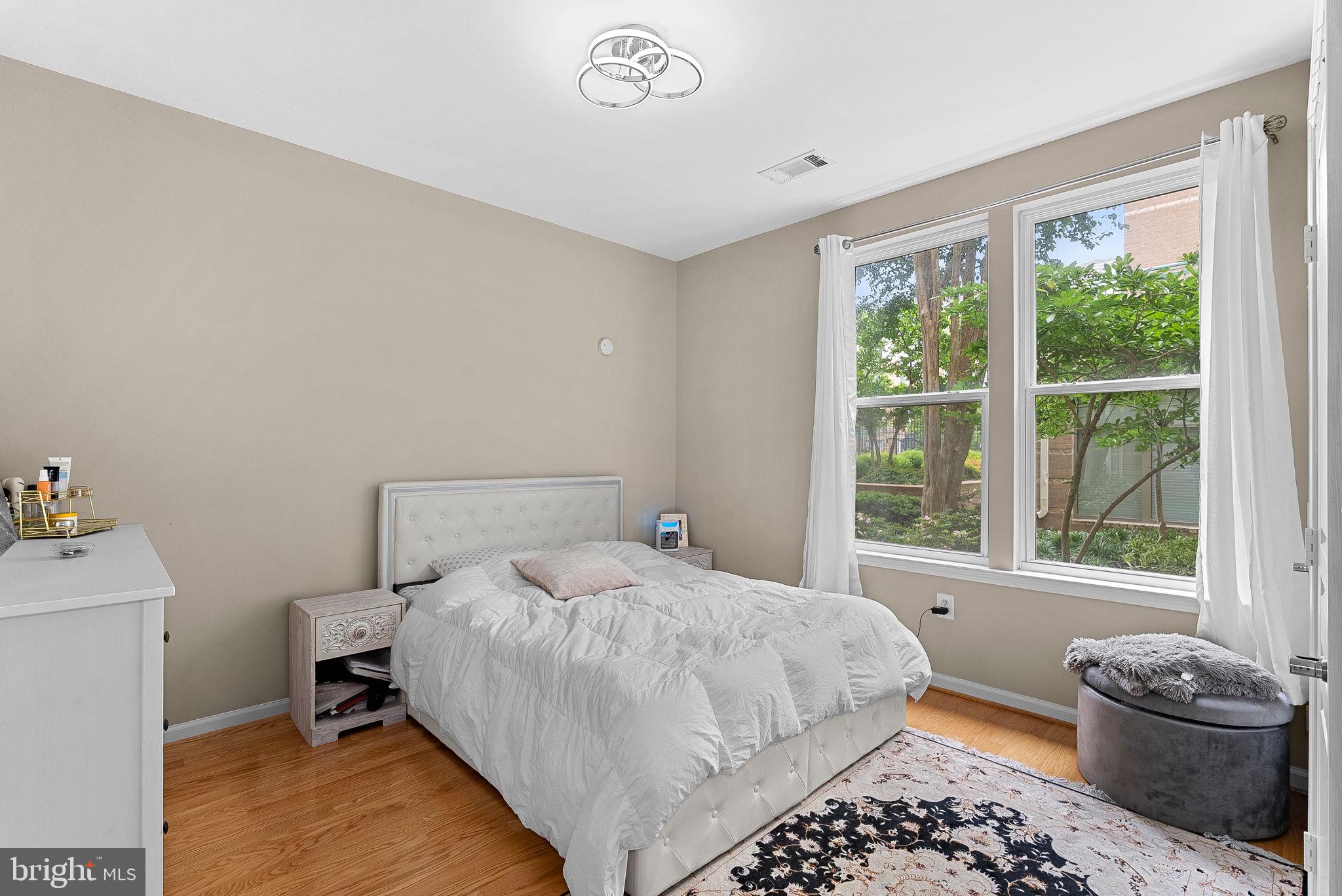 12001 Market Street, Unit 106 Reston, VA 20190 - Photo 19 of 45 a bedroom with a bed and a window