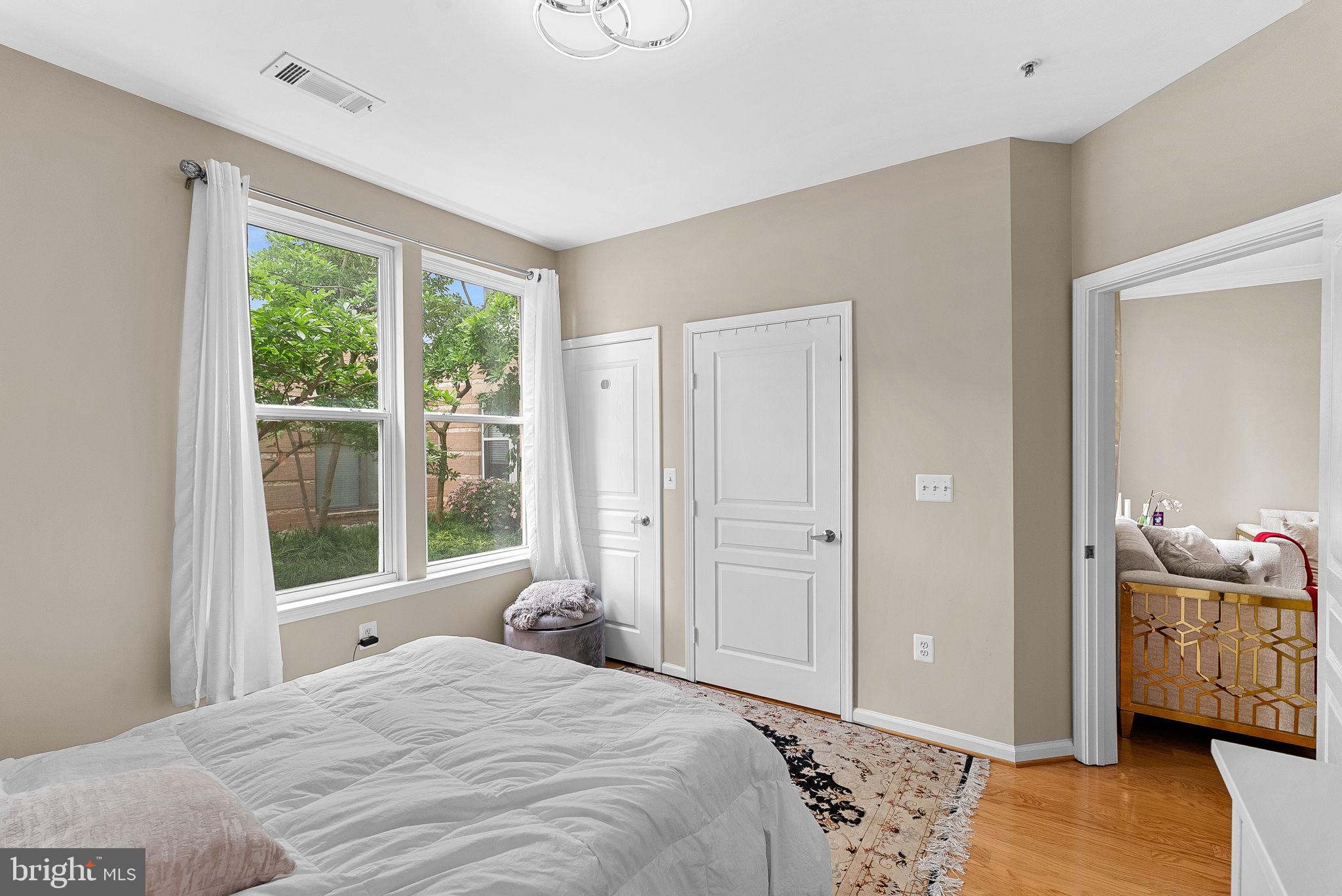 12001 Market Street, Unit 106 Reston, VA 20190 - Photo 20 of 45 a bedroom with a bed and wooden floor