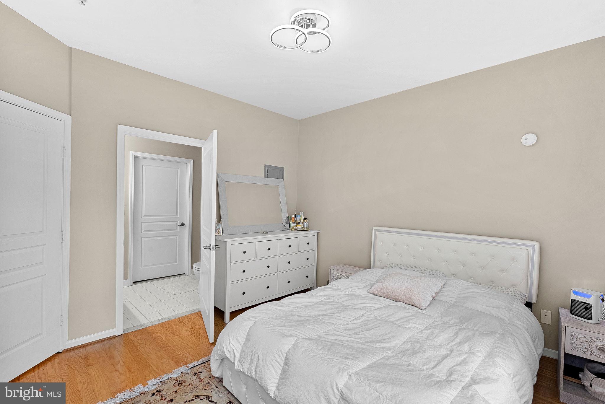 12001 Market Street, Unit 106 Reston, VA 20190 - Photo 21 of 45 a bedroom with a bed and a dresser