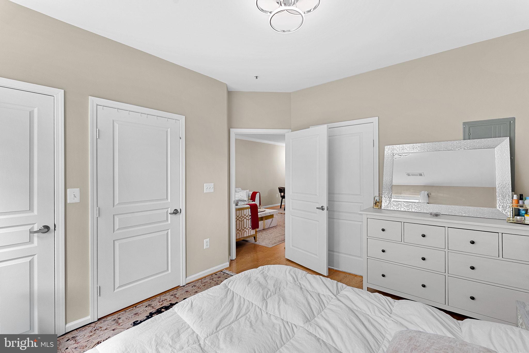 12001 Market Street, Unit 106 Reston, VA 20190 - Photo 22 of 45 a bedroom with a bed and a cabinets