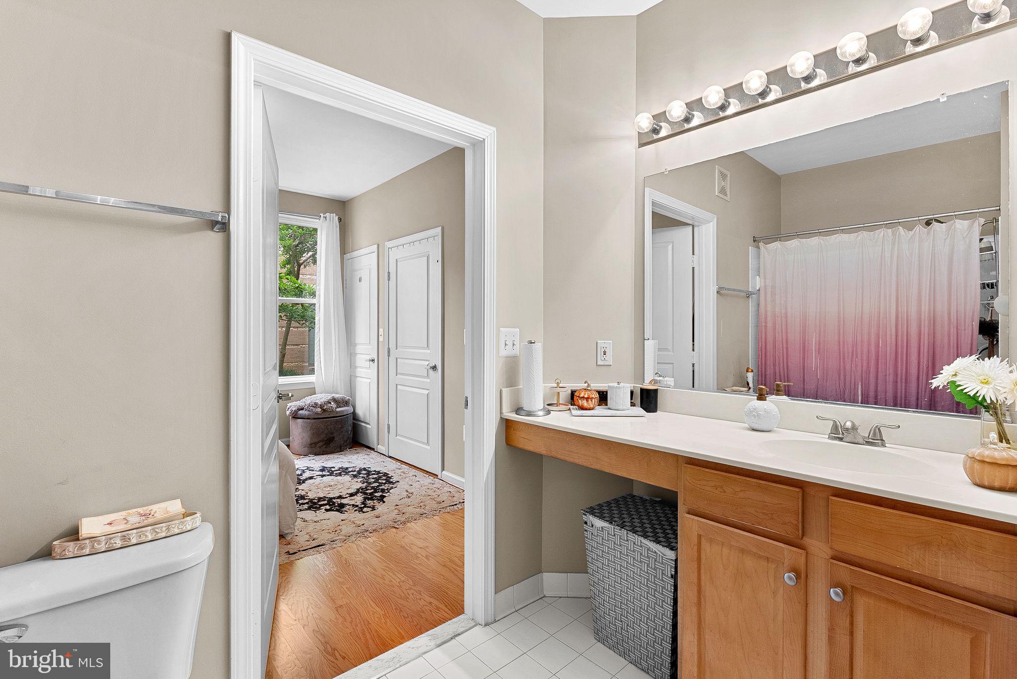 12001 Market Street, Unit 106 Reston, VA 20190 - Photo 25 of 45 a en suite bathroom with a sink vanity granite and a mirror