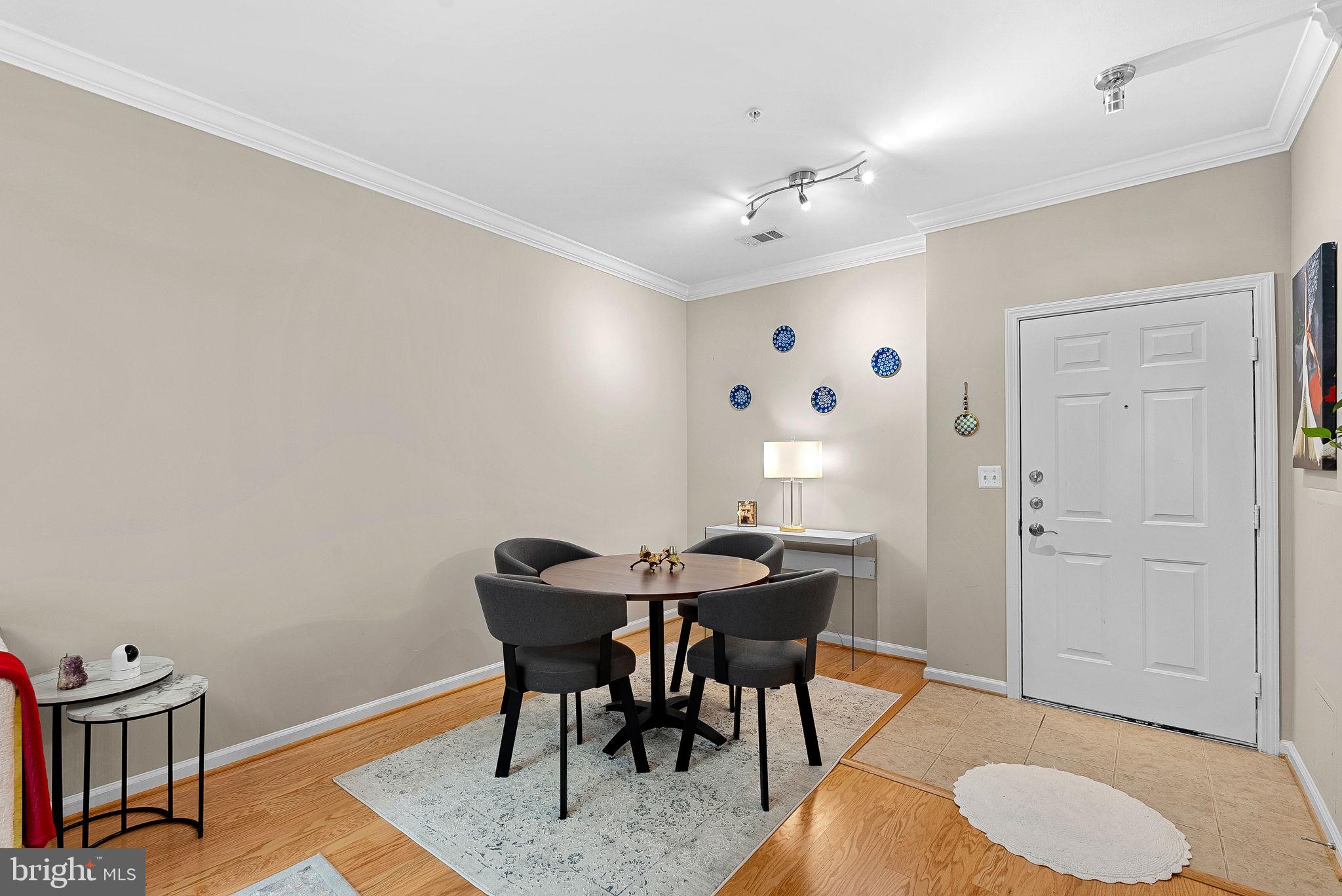 12001 Market Street, Unit 106 Reston, VA 20190 - Photo 7 of 45 a view of a dining room with furniture and wooden floor