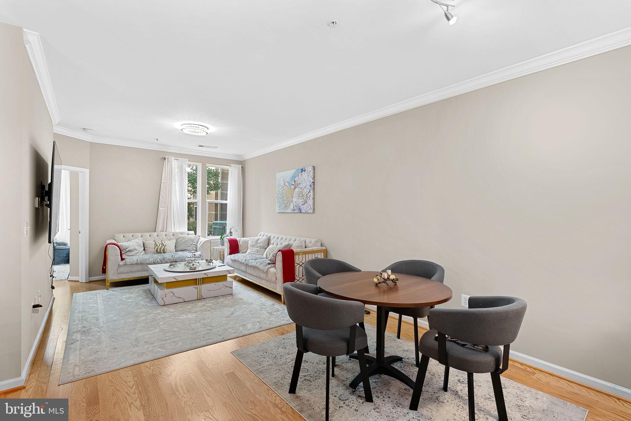 12001 Market Street, Unit 106 Reston, VA 20190 - Photo 8 of 45 a living room with furniture and a window