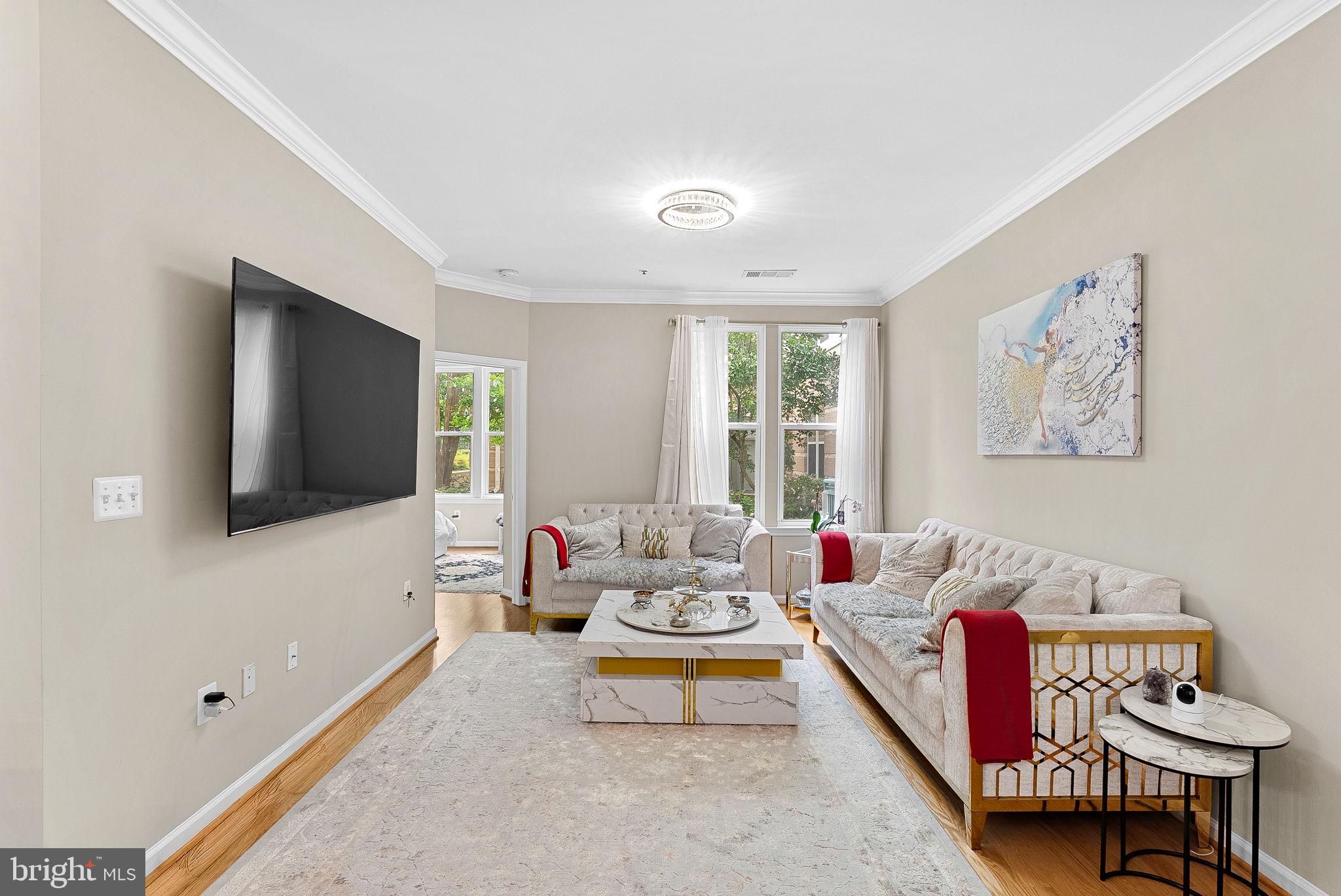 12001 Market Street, Unit 106 Reston, VA 20190 - Photo 10 of 45 a living room with furniture and a flat screen tv