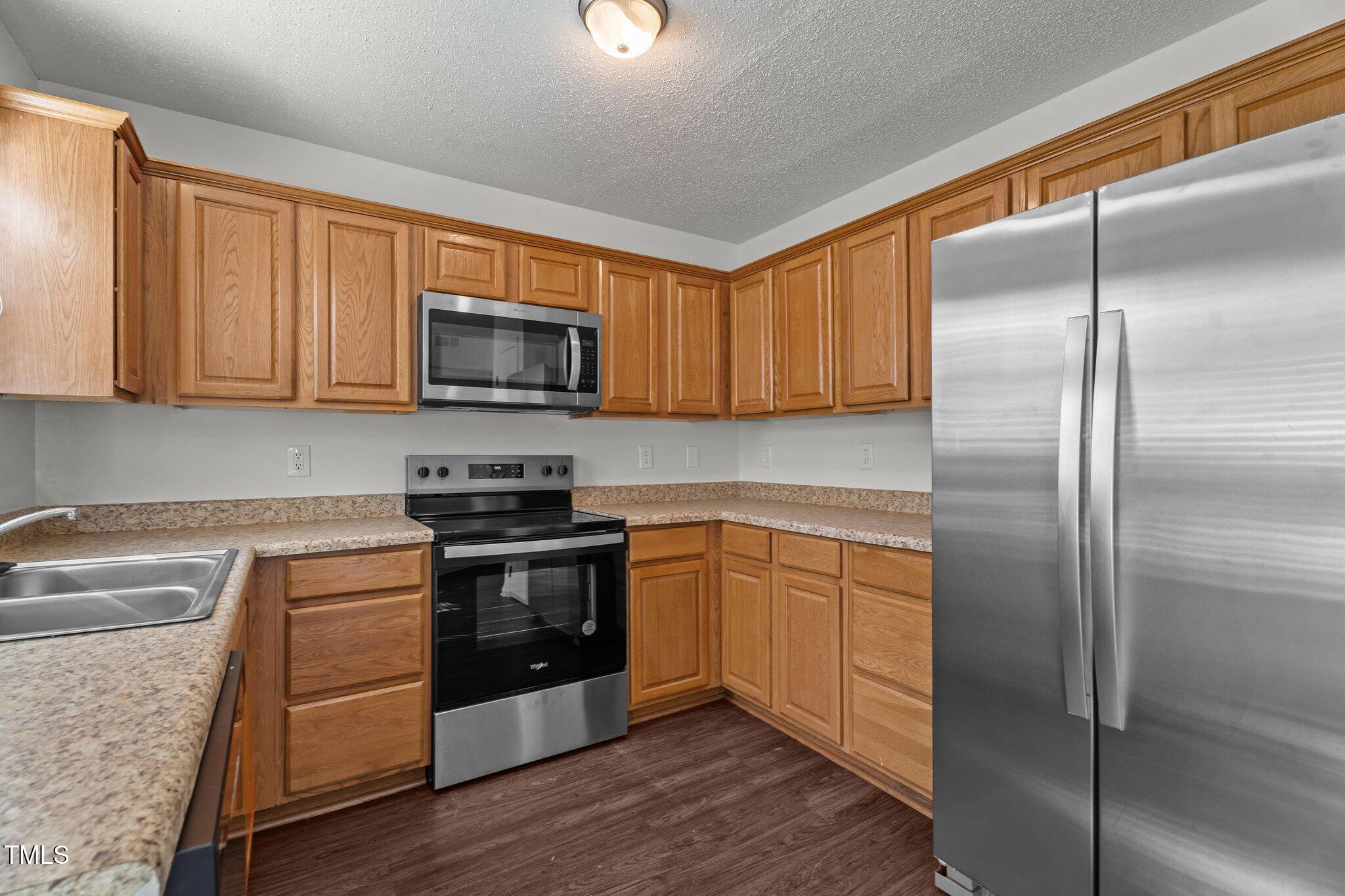 3624 Singleleaf Lane Raleigh, NC 27616 - Photo 18 of 40 a kitchen with a refrigerator stove top oven and sink