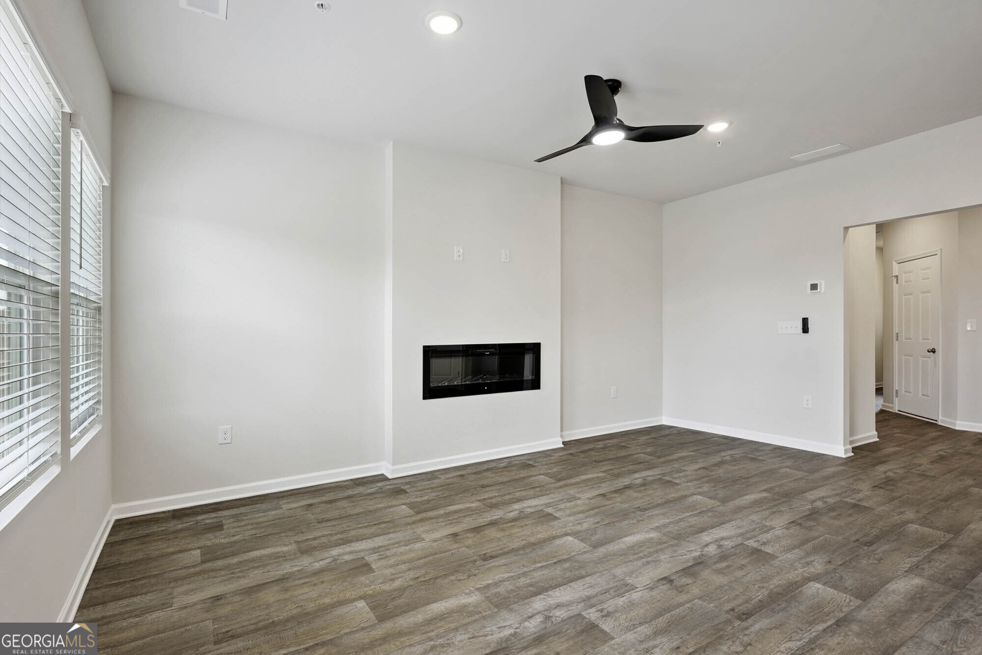 11516 Kimberly Way Hampton, GA 30228 - Photo 10 of 39 a view of an empty room with wooden floor and a window