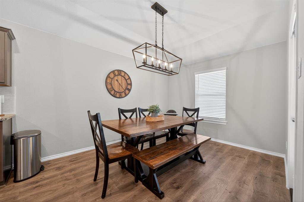 800 Rustic Way Royse City, TX 75189 - Photo 10 of 21 a dining room with wooden floor a chandelier a wooden table and chairs