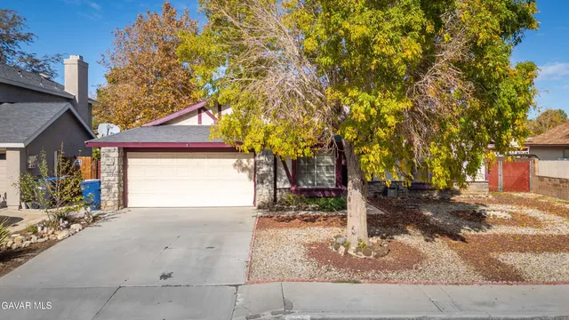 a view of a house with a tree and garage