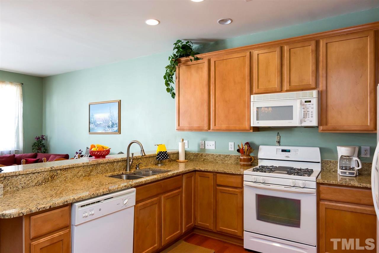 8228 Belneath Court Raleigh, NC 27613 - Photo 4 of 17 a kitchen with stainless steel appliances granite countertop a sink stove and cabinets