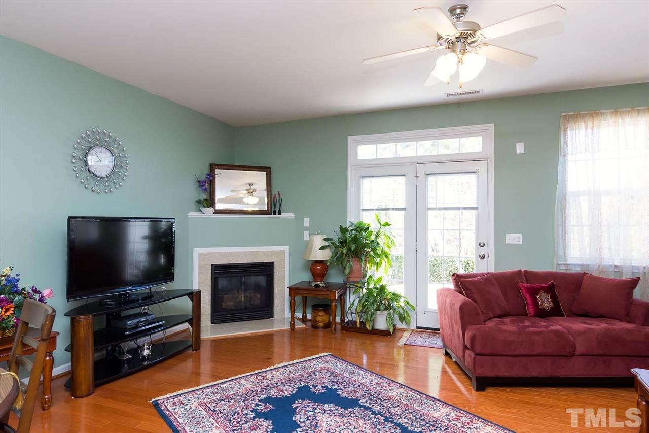 8228 Belneath Court Raleigh, NC 27613 - Photo 6 of 17 a living room with furniture a flat screen tv and a fireplace