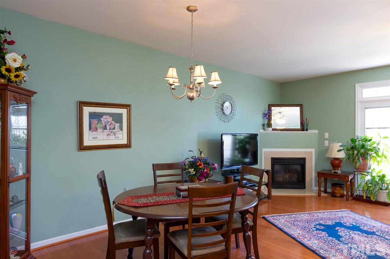 8228 Belneath Court Raleigh, NC 27613 - Photo 8 of 17 a dining room with furniture a fireplace and a chandelier