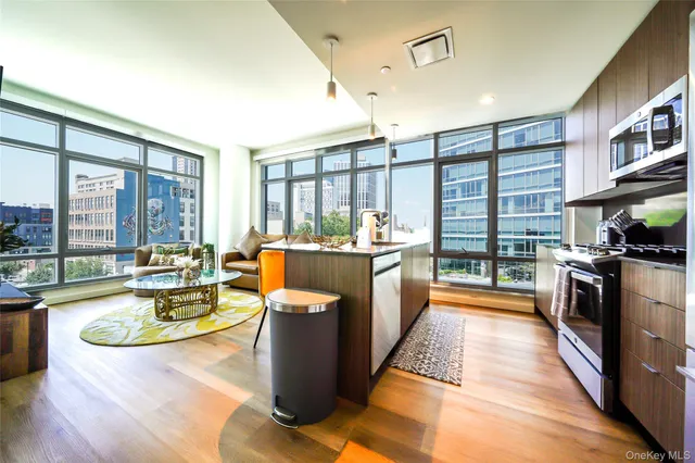 a large kitchen with stainless steel appliances granite countertop a large window and a counter space