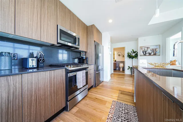 a kitchen with stainless steel appliances granite countertop a stove a sink and a microwave