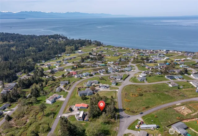 an aerial view of ocean and residential houses with outdoor space