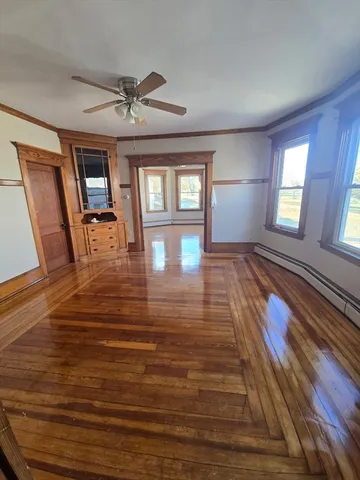 a view of a livingroom with wooden floor and a ceiling fan