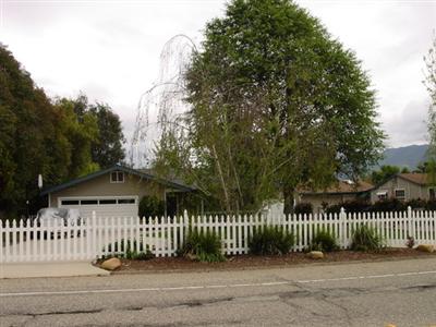 984 Tico Road Ojai, CA 93023 - Photo 6 of 6 From across the street this shows a photo of the picket fencing and large tree. The attached two car garage and circle drive.