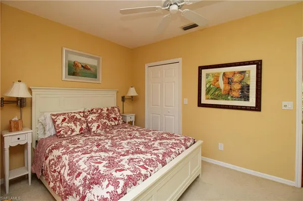 a bedroom with a bed and a lamp on dresser