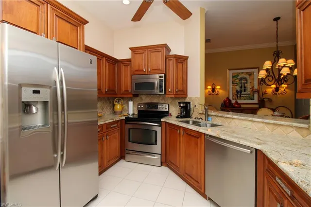 a kitchen with stainless steel appliances granite countertop a refrigerator a stove and a sink
