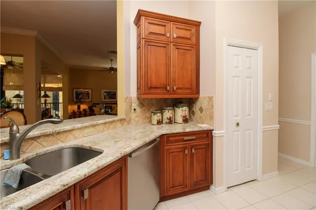 a kitchen with stainless steel appliances granite countertop a sink and dishwasher with wooden cabinets