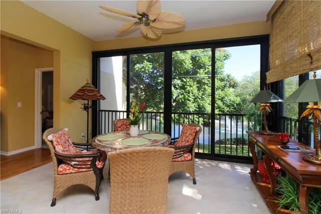 a dining room with furniture water view and a floor to ceiling window