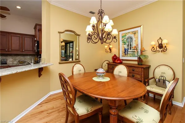 a dining room with furniture a chandelier and wooden floor