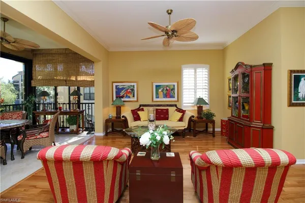 a living room with furniture dining table a chandelier fan and a window