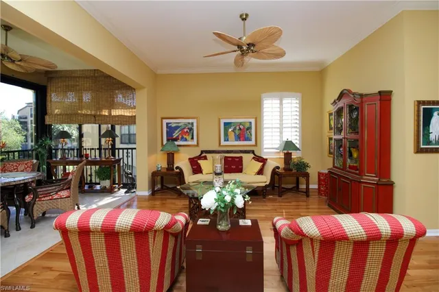 a living room with furniture dining table a chandelier fan and a window