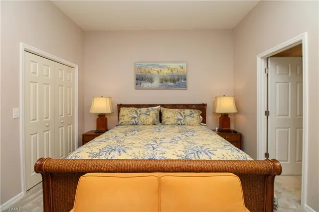 a bedroom with a bed and a lamp on dresser