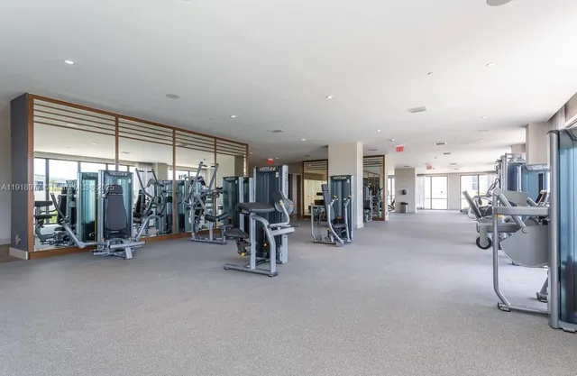 a room with gym equipment and large windows