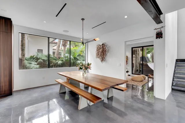 a bedroom with a bed a chair and potted plant on the dresser