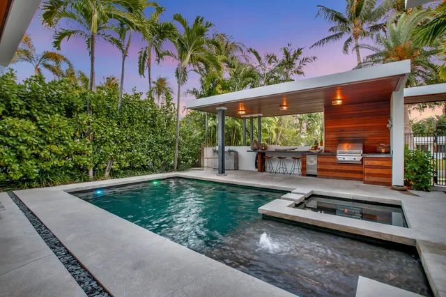 a view of a dining room with furniture a potted plant and wooden floor