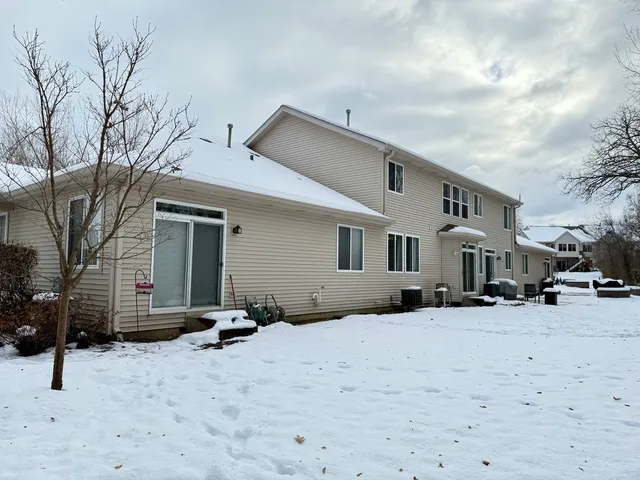 a front view of a house with a yard covered in snow