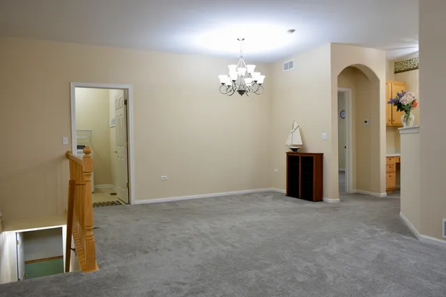 an empty room with chandelier fan