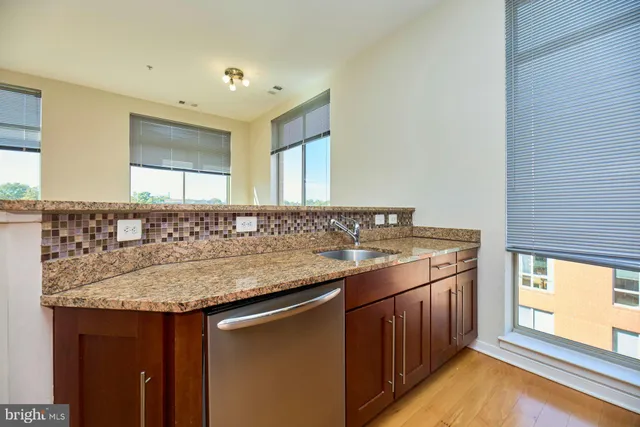 a bathroom with a granite countertop sink and a large mirror