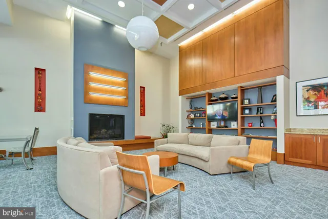 a living room with furniture a flat screen tv and kitchen view