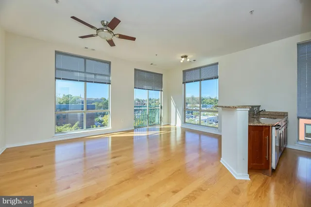 a view of open kitchen with wooden floor and a window