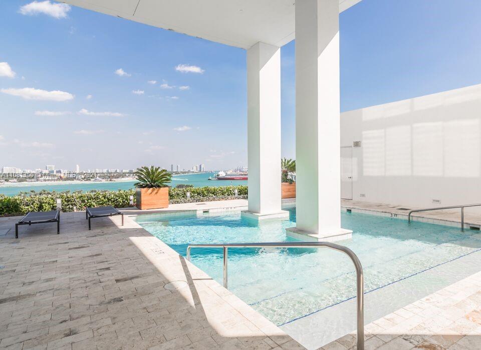1040 Biscayne Boulevard, Unit 2403 Miami, FL 33132 - Photo 17 of 25 a view of a swimming pool with a lounge chairs