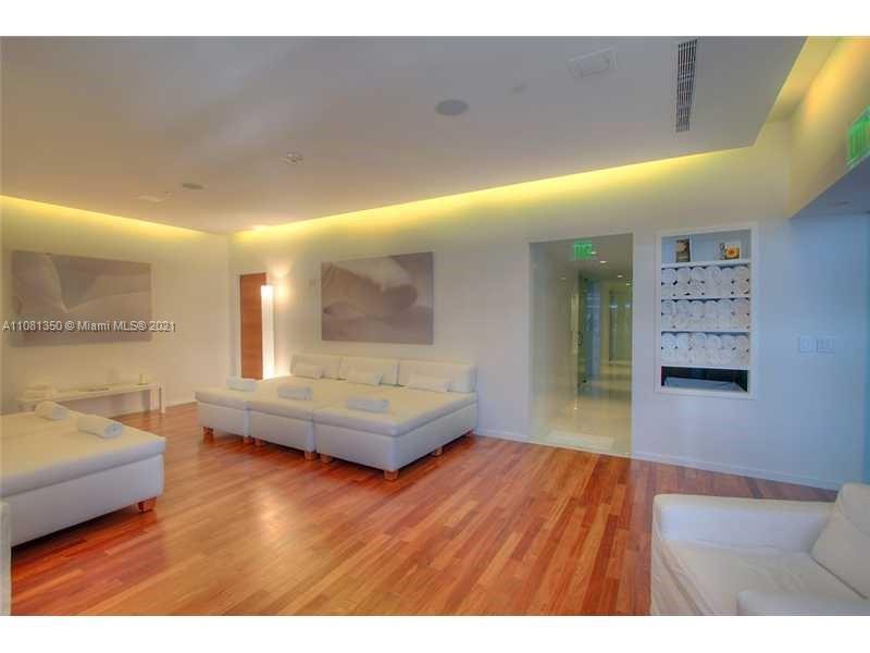 1040 Biscayne Boulevard, Unit 2403 Miami, FL 33132 - Photo 21 of 25 a living room with furniture and a wooden floor