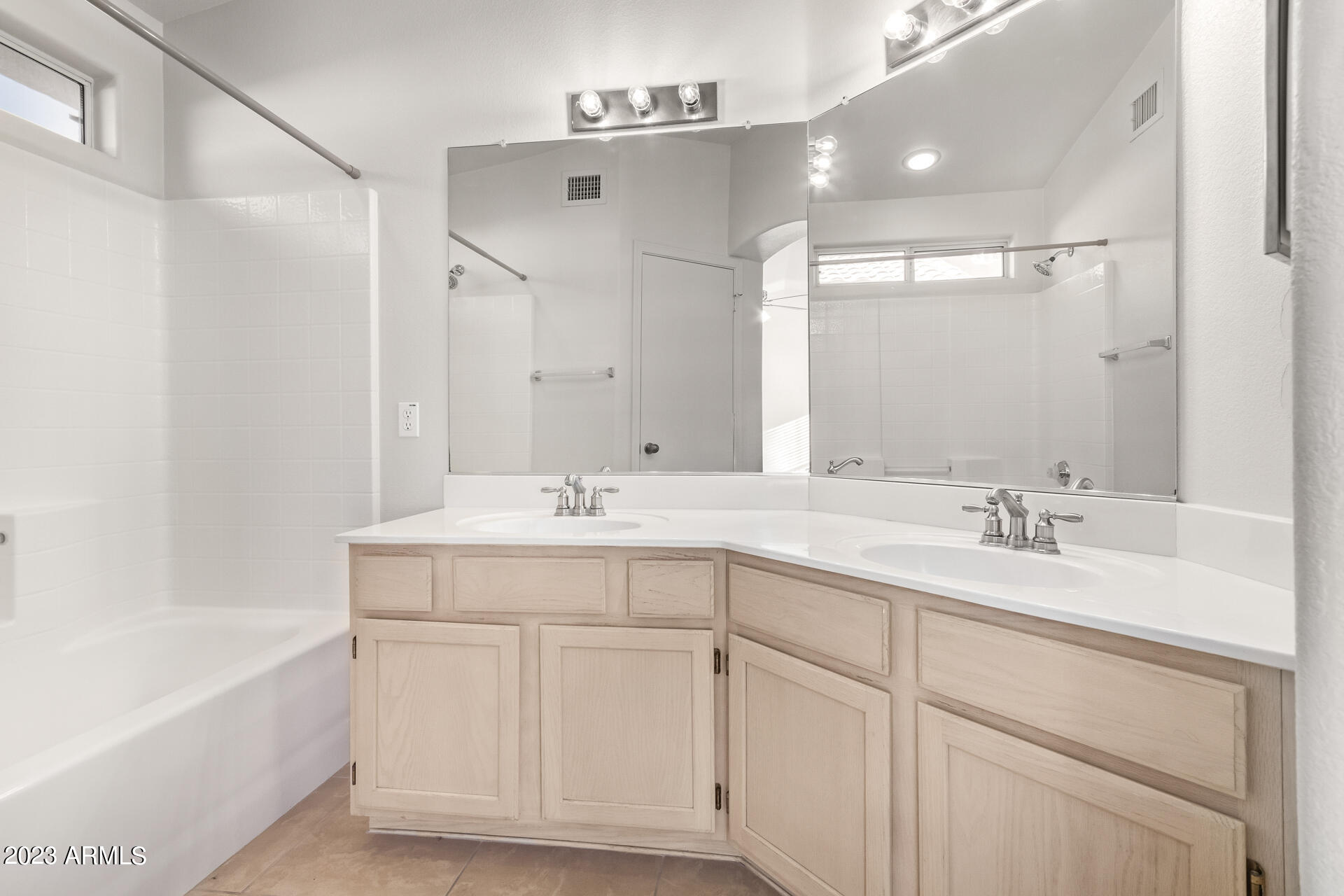 1310 East Angela Drive Phoenix, AZ 85022 - Photo 11 of 19 a bathroom with a double vanity sink a mirror and a bathtub
