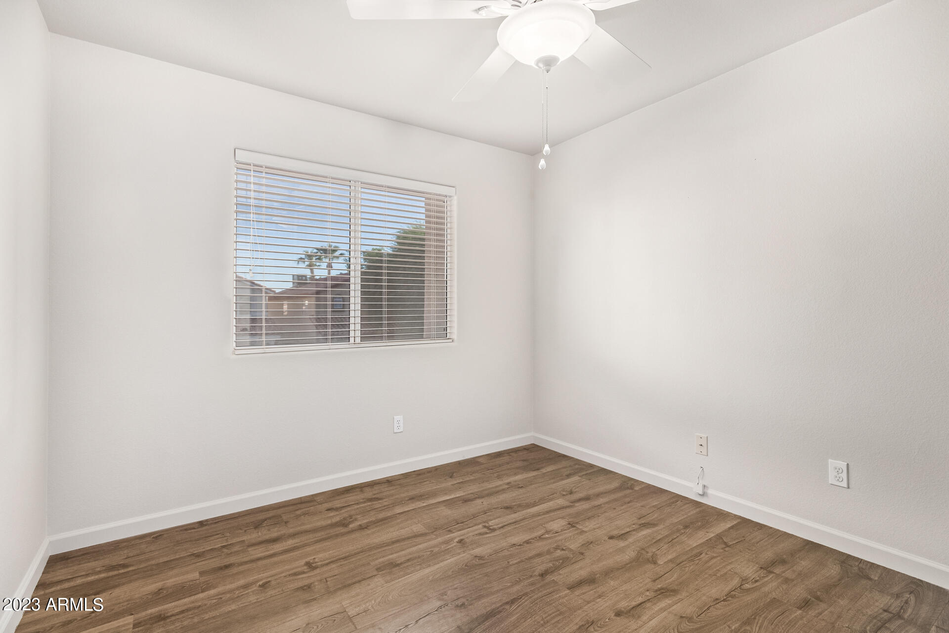 1310 East Angela Drive Phoenix, AZ 85022 - Photo 13 of 19 an empty room with wooden floor and windows