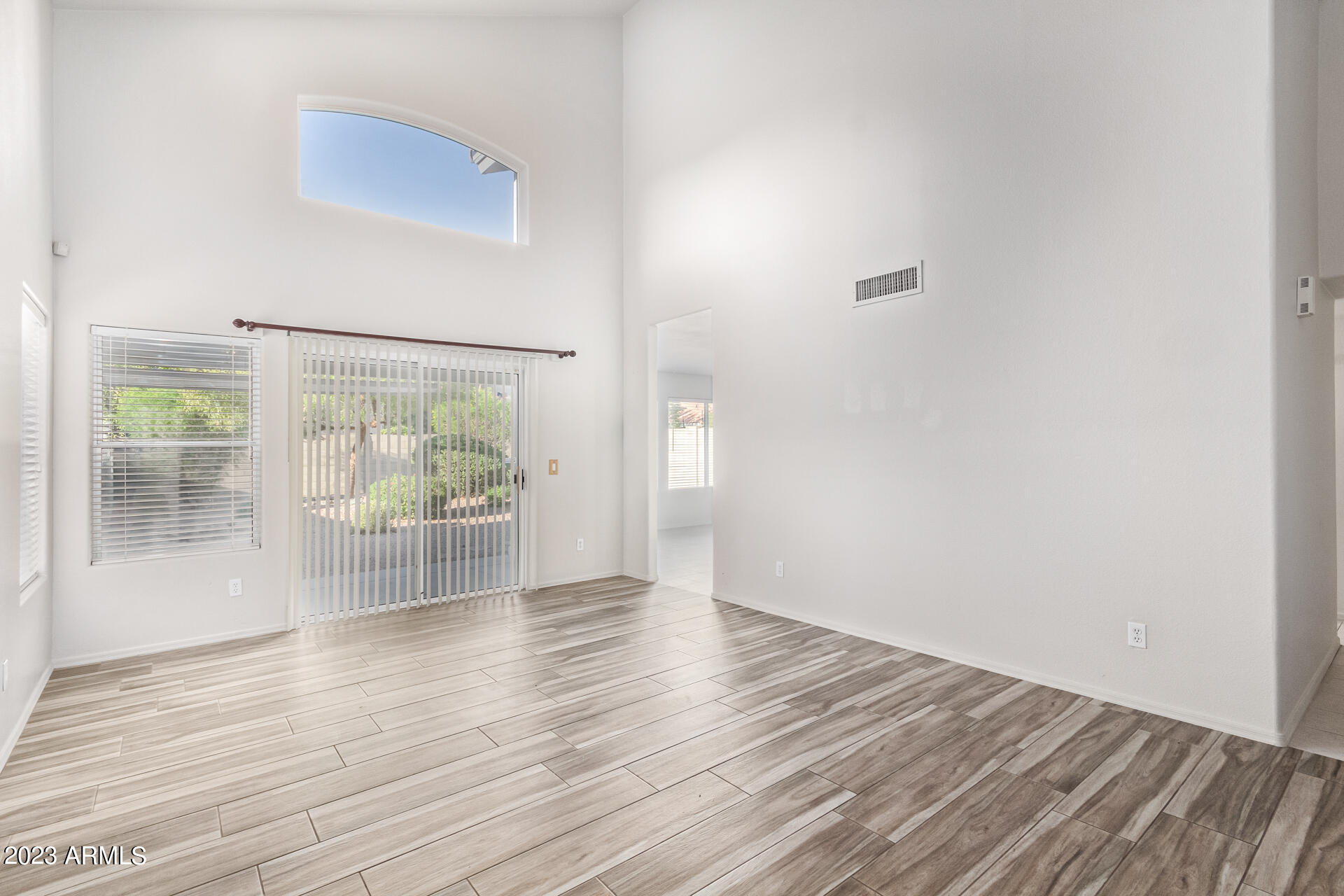 1310 East Angela Drive Phoenix, AZ 85022 - Photo 2 of 19 an empty room with wooden floor and windows