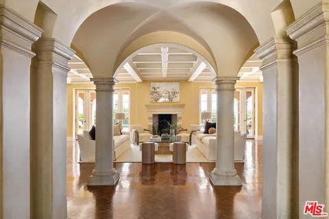 a living room with fireplace furniture and a large window