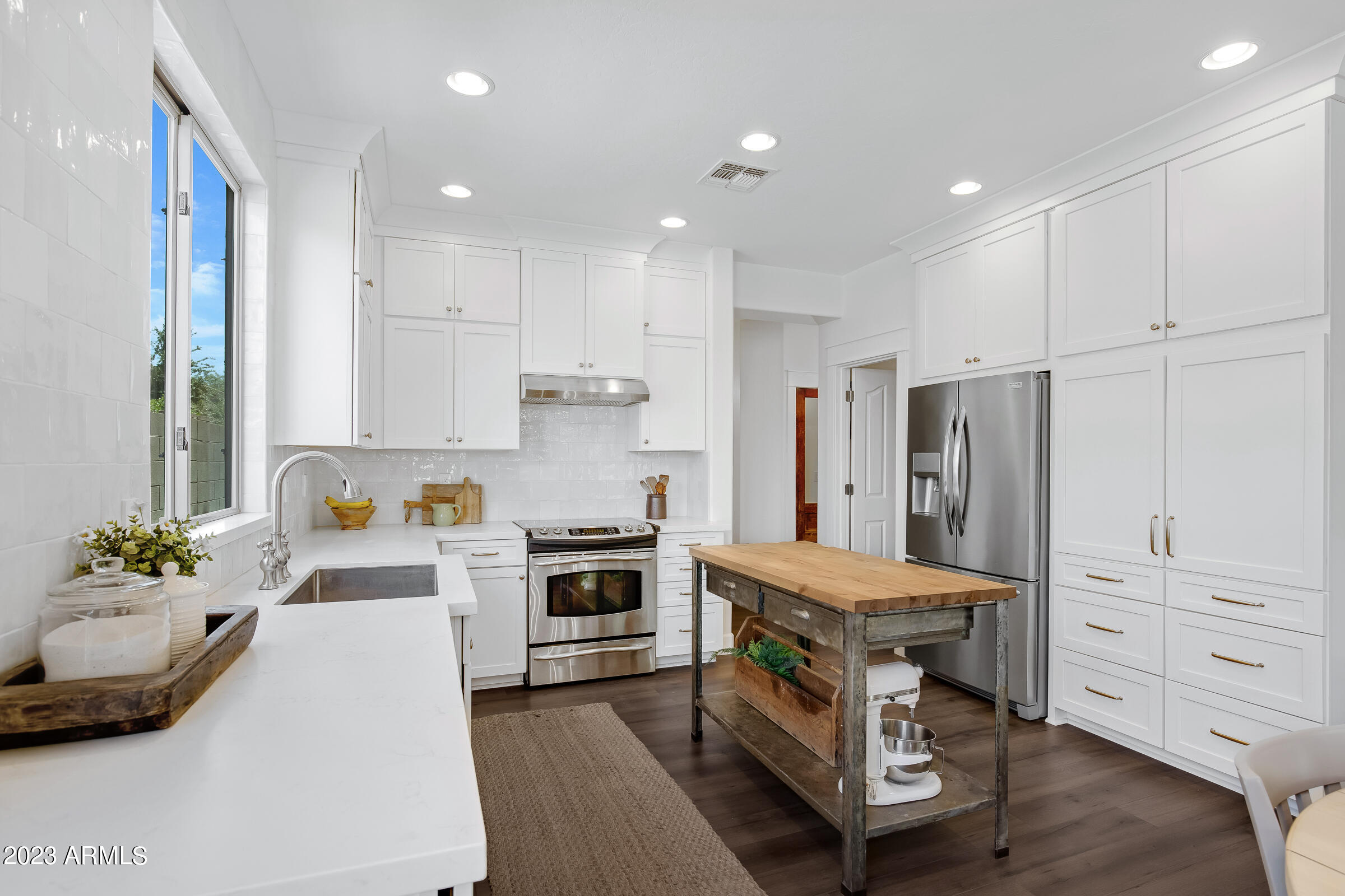 4736 East Timberline Road Gilbert, AZ 85297 - Photo 14 of 49 a kitchen with white cabinets and stainless steel appliances