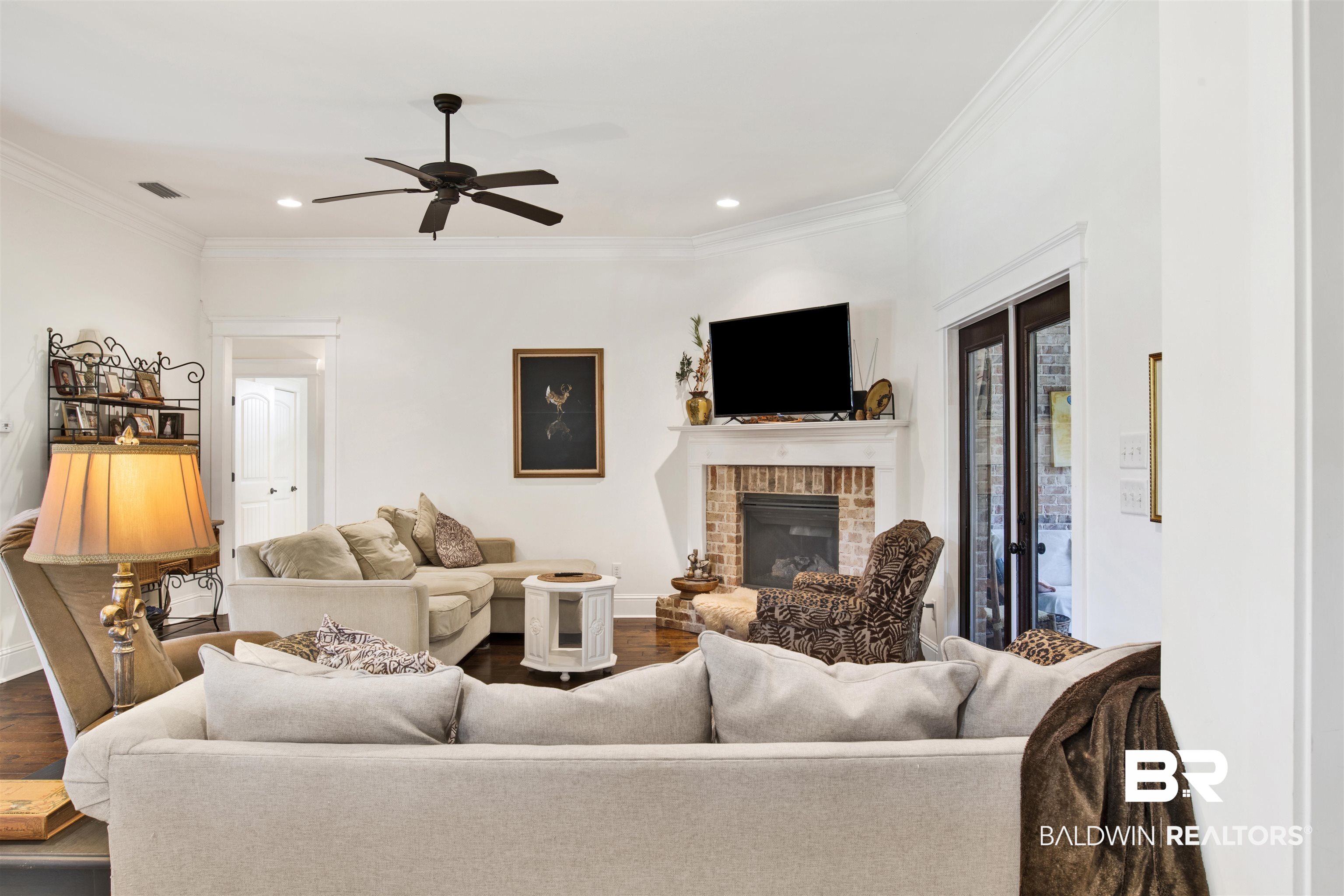 9240 Bay Point Drive Elberta, AL 36530 - Photo 13 of 22 Living room with ceiling fan, a fireplace, crown molding, and wood-type flooring