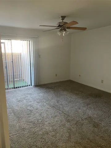 en empty room with windows and fan