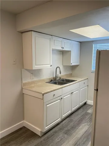 a kitchen with a sink a refrigerator and cabinets