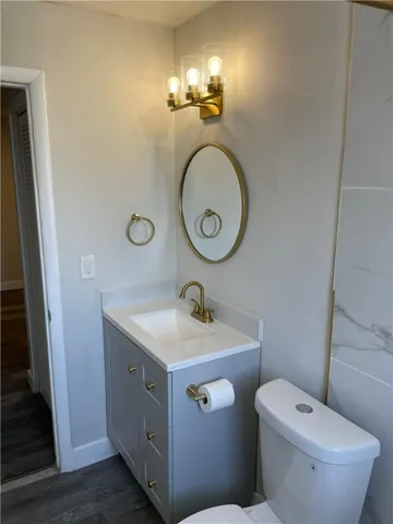 a bathroom with a toilet a sink and a mirror