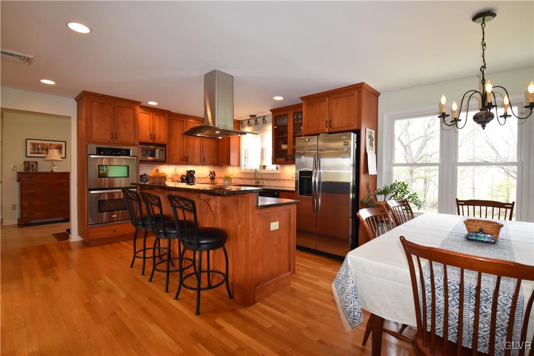 2996 Georgetown Road Nazareth, PA 18064 - Photo 7 of 36 a kitchen with stainless steel appliances wooden floor dining table and chairs