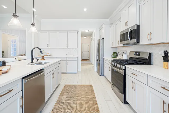a kitchen with stainless steel appliances a sink stove top oven and refrigerator